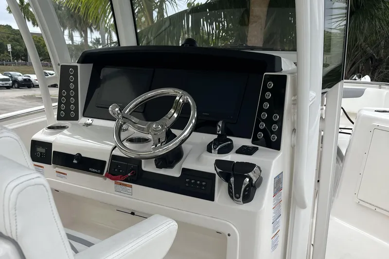 Slide: The Image of 2023 Robalo R302 Center Console boat dashboard with steering wheel and controls. - 20