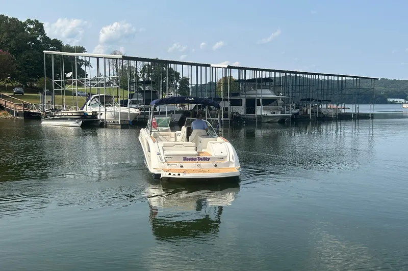 Slide: The Image of 2008 Sea Ray 290 Sundeck boat near marina with covered docks and calm water. - 3