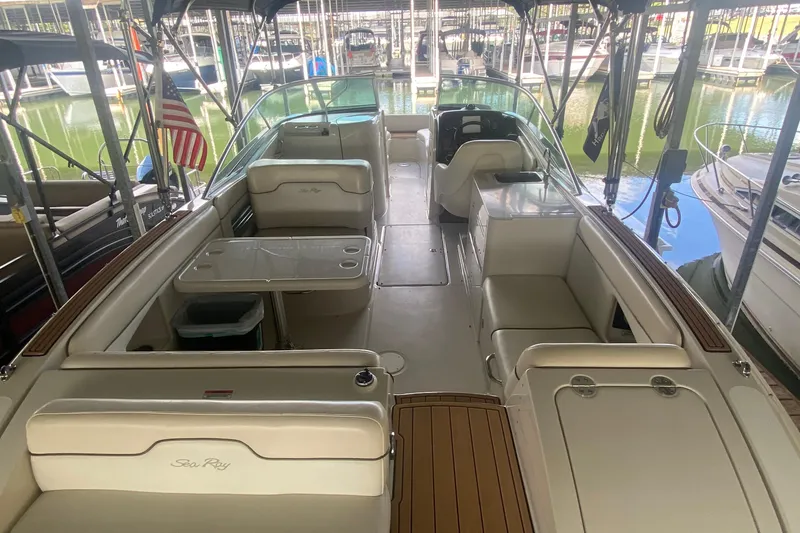 Slide: The Image of 2008 Sea Ray 290 Sundeck boat interior with seating and table in a marina. - 7