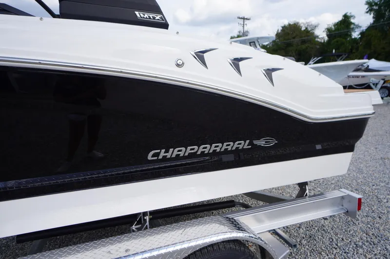 Slide: The Image of 2026 Chaparral 21 SSi boat on trailer, featuring sleek black and white design. - 2