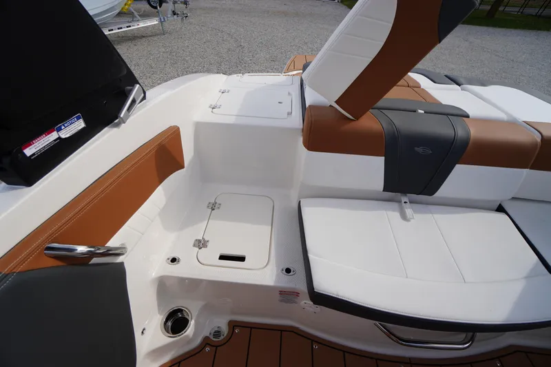 Slide: The Image of 2026 Chaparral 21 SSi boat interior with white and brown seating, storage compartment. - 33
