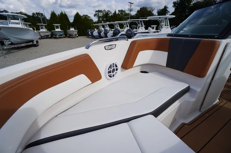 Slide: The Image of 2026 Chaparral 21 SSi boat interior with brown and white seating, speaker, and cup holder. - 8