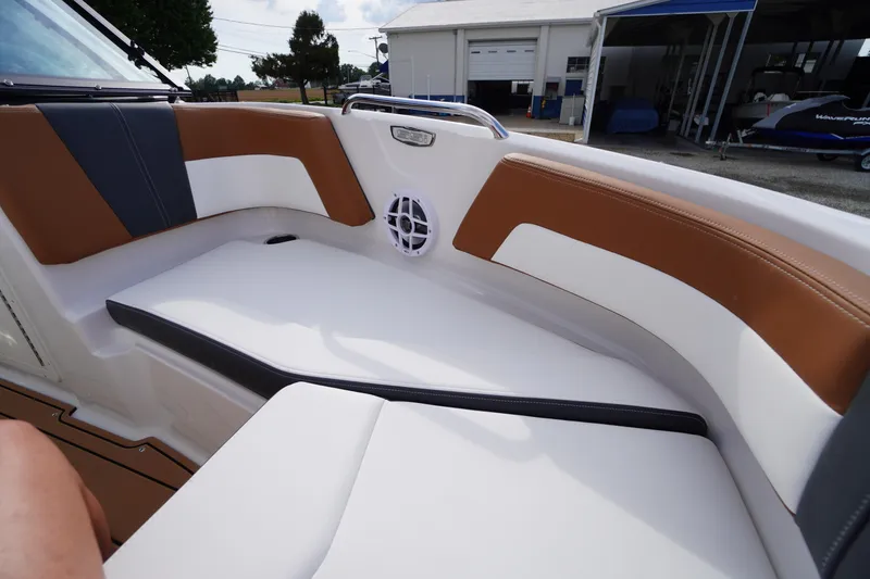 Slide: The Image of 2026 Chaparral 21 SSi boat interior with brown and white seating, outdoor setting. - 9