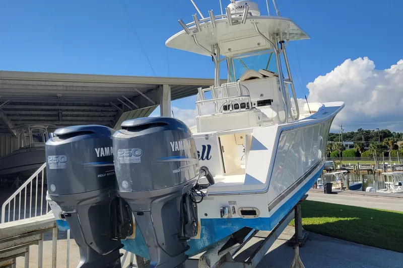 Slide: The Image of 2006 Regulator 29 Forward Seating boat with twin Yamaha 250 engines, docked under clear skies. - 2