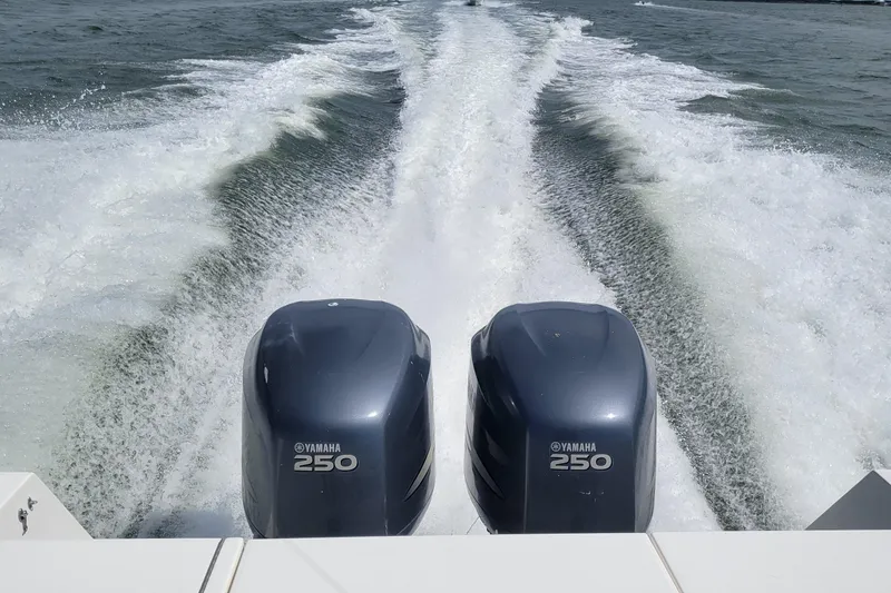 Slide: The Image of Twin Yamaha 250 engines powering a 2006 Regulator 29 Forward Seating boat on open water. - 7