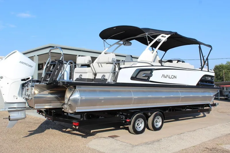 Slide: The Image of 2026 Avalon Excalibur LTD Quad Lounge 25 FT pontoon boat on trailer, featuring Mercury engine. - 3