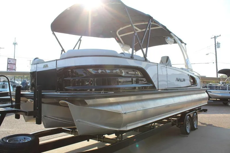 Slide: The Image of 2026 Avalon Excalibur LTD Quad Lounge 25 FT pontoon boat on trailer, sunlit background. - 5