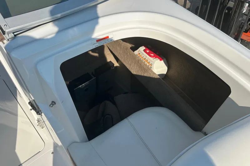 Slide: The Image of Storage compartment in a 2011 Cobalt 242 boat, featuring a fire extinguisher. - 20