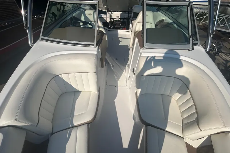 Slide: The Image of 2011 Cobalt 242 boat interior with white leather seating and open cockpit. - 21