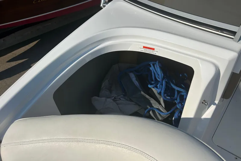 Slide: The Image of Storage compartment in a 2011 Cobalt 242 boat with blue rope inside. - 22