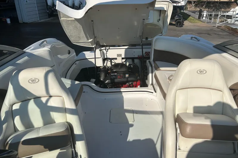 Slide: The Image of 2011 Cobalt 242 boat interior with open engine compartment, showcasing seating and engine details. - 23