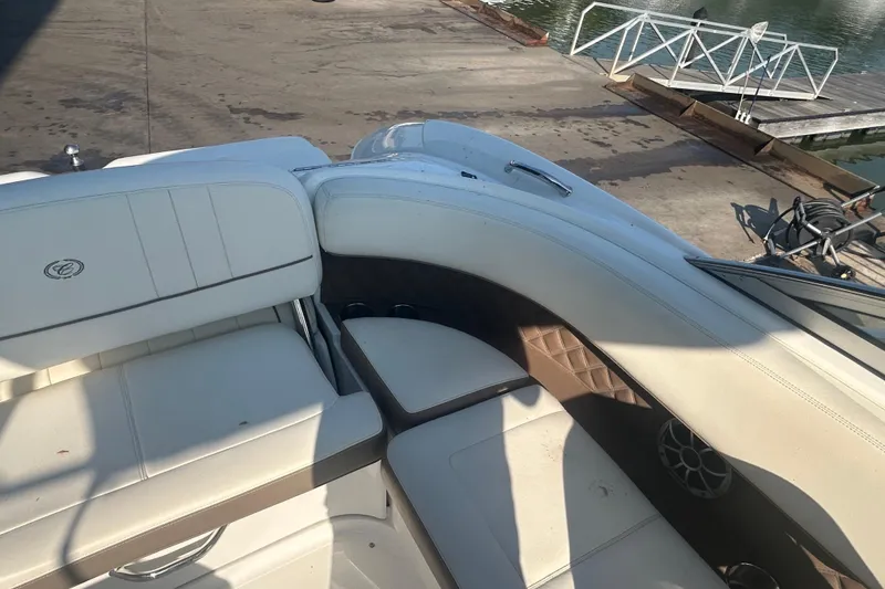 Slide: The Image of Interior of a 2011 Cobalt 242 boat with white seating and dockside view. - 9