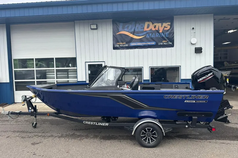 Slide: The Image of 2025 Crestliner 1750 Hawk boat in blue, parked outside Lake Days Marine. - 1