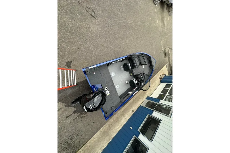 Slide: The Image of 2025 Crestliner 1750 Hawk boat, aerial view, parked near a building, featuring a 115 HP motor. - 10