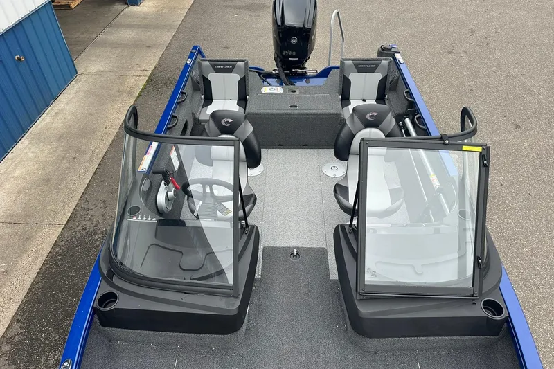 Slide: The Image of 2025 Crestliner 1750 Hawk boat interior with dual consoles and seating, parked on pavement. - 13