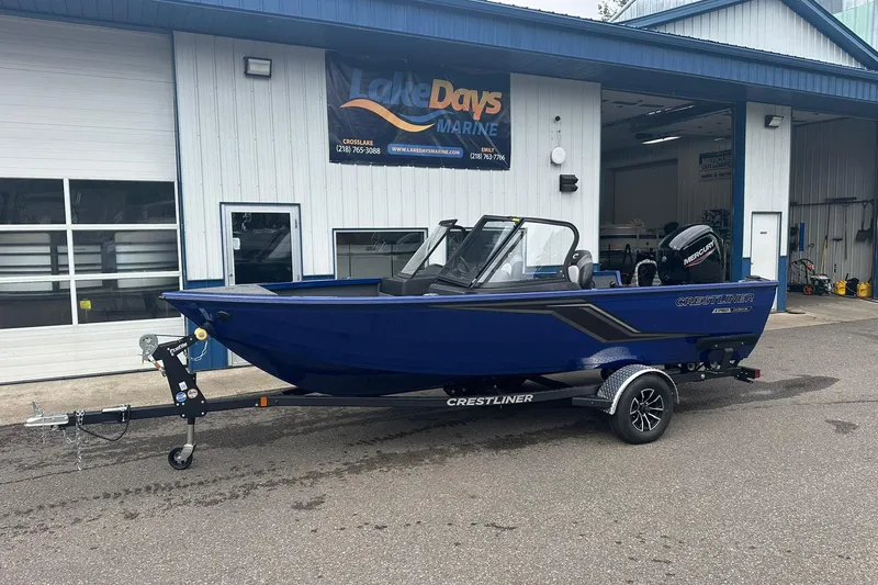 Slide: The Image of 2025 Crestliner 1750 Hawk boat in blue, parked outside Lake Days Marine shop. - 2