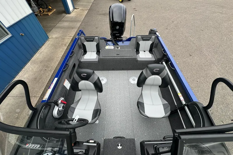 Slide: The Image of 2025 Crestliner 1750 Hawk boat interior with seating and steering wheel, parked outdoors. - 21