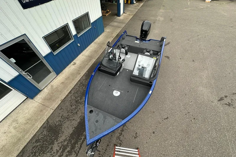 Slide: The Image of 2025 Crestliner 1750 Hawk boat parked outside a building, showcasing sleek design and spacious deck. - 8