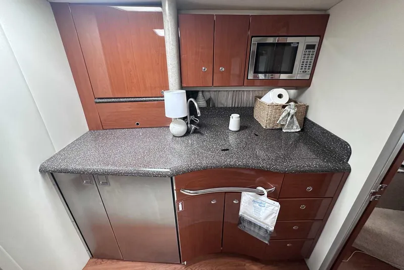 Slide: The Image of 2007 Formula 40 Performance Cruiser kitchen with wood cabinets, microwave, and granite countertop. - 26