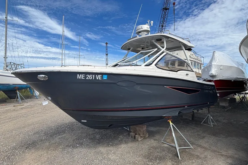 The Image of 2024 Solara S-250 DC boat on stands, ready for launch under a clear blue sky. - 1