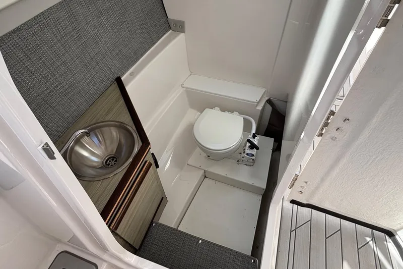 Slide: The Image of 2024 Solara S-250 DC boat interior with compact bathroom and stainless steel sink. - 11