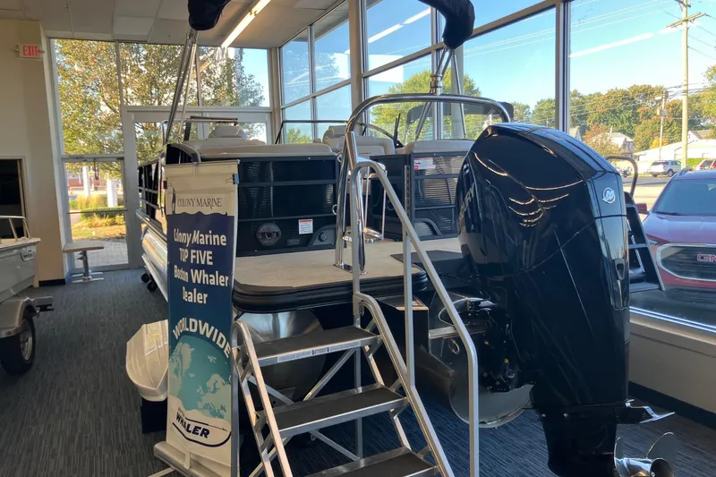 Slide: The Image of 2026 Crest Continental 250 SLC boat displayed indoors with powerful outboard motor. - 3