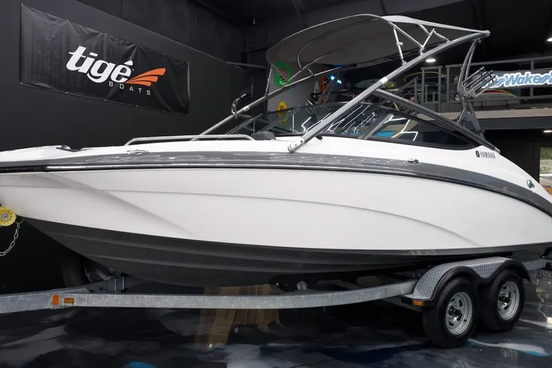 The Image of 2015 Yamaha Boats 212X on trailer in showroom, featuring sleek design and modern features. - 0