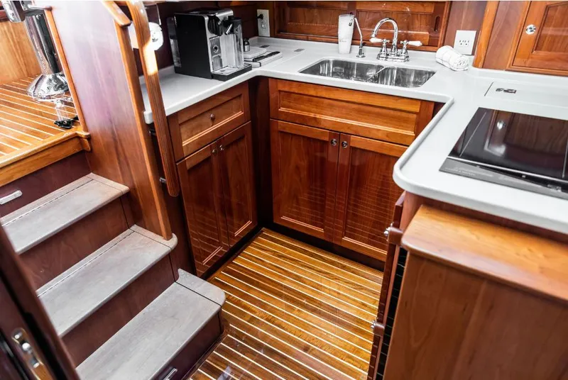Slide: The Image of 2013 Hinckley Talaria 48 MY yacht kitchen with wooden cabinetry and modern appliances. - 20
