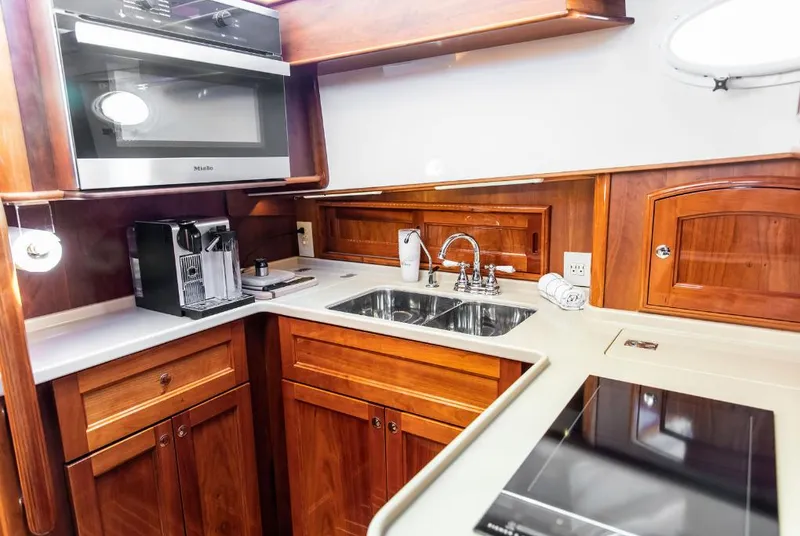 Slide: The Image of Luxurious kitchen in 2013 Hinckley Talaria 48 MY yacht with wood cabinetry and modern appliances. - 21