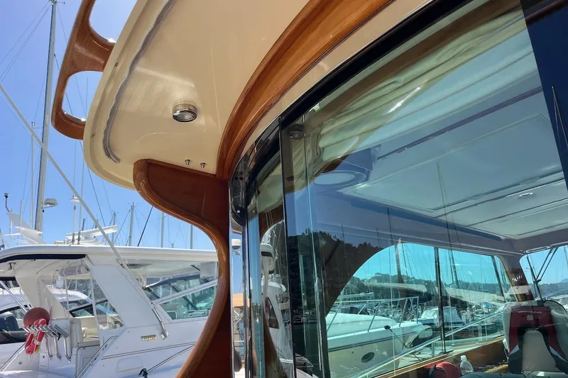 Slide: The Image of 2013 Hinckley Talaria 48 MY yacht with sleek design and reflective windows in a marina. - 32