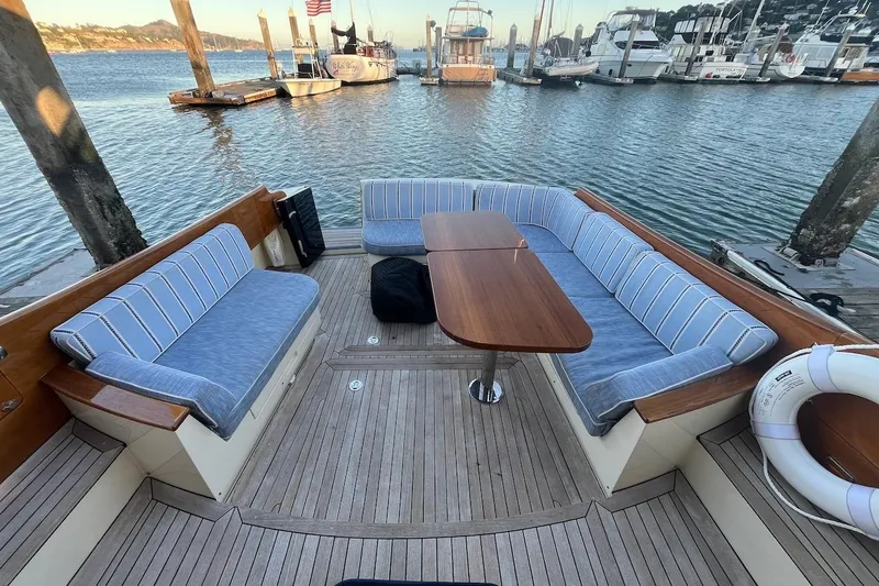 Slide: The Image of Hinckley Talaria 48 MY 2013 yacht deck with cushioned seating and wooden table. - 4