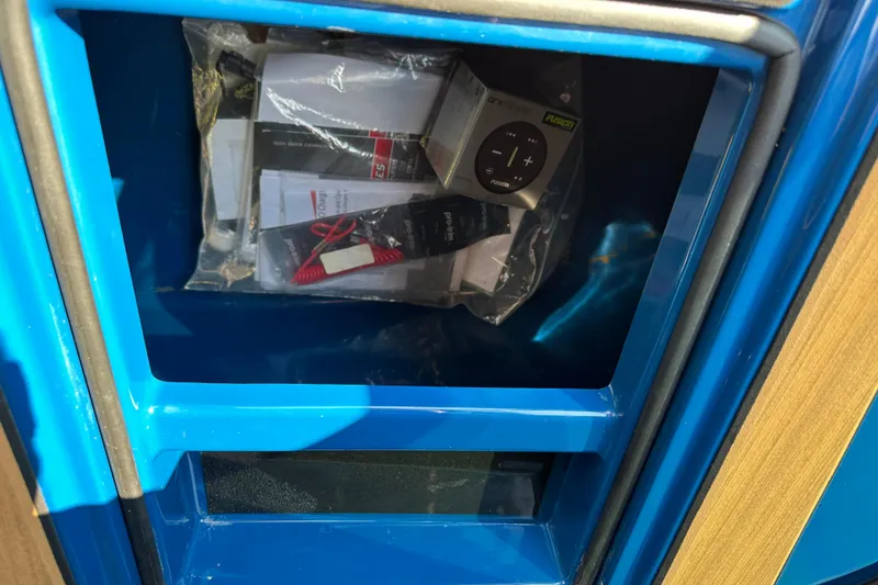 Slide: The Image of Storage compartment in a 2022 Moomba Makai boat, containing manuals and accessories. - 14
