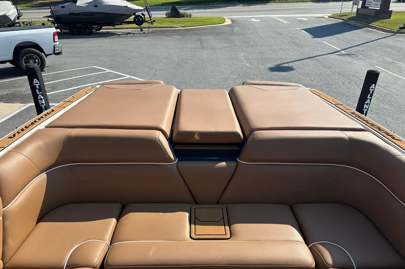 Slide: The Image of 2022 Moomba Makai boat interior with tan leather seating in a parking lot. - 23