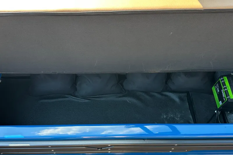 Slide: The Image of 2022 Moomba Makai storage compartment with battery and cushions, featuring blue exterior. - 9