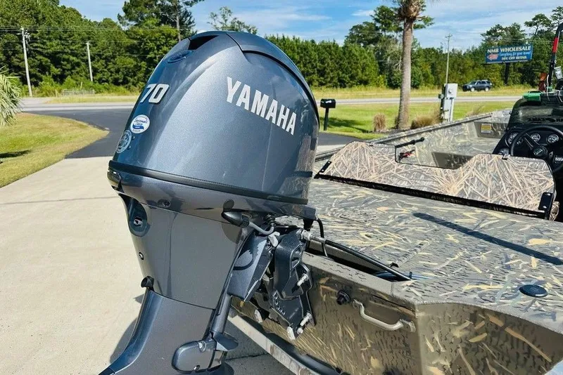 Slide: The Image of 2026 War Eagle 754LDSV boat with Yamaha 70 outboard motor, camo design, parked outdoors. - 7