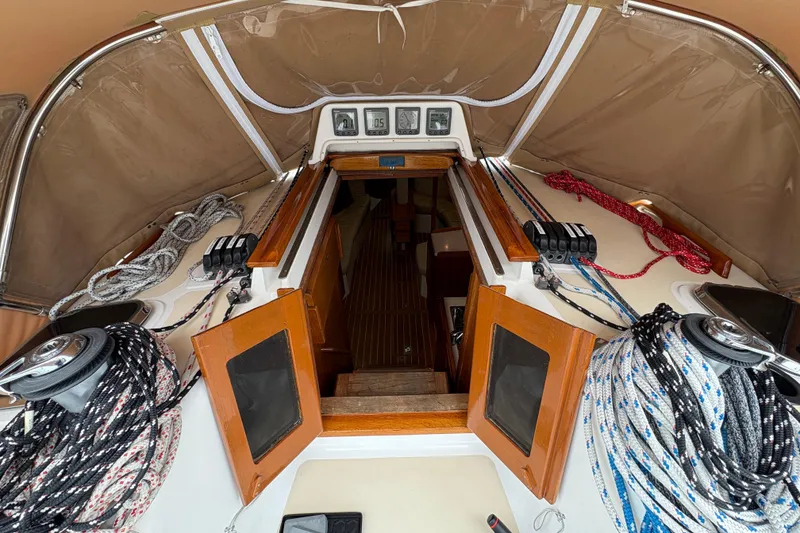 Slide: The Image of Interior view of a 2007 Tartan 3700 CCR sailboat cockpit with ropes and wooden hatch. - 16