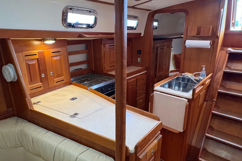 Slide: The Image of Interior of 2007 Tartan 3700 CCR sailboat with wooden cabinetry and compact kitchen. - 30