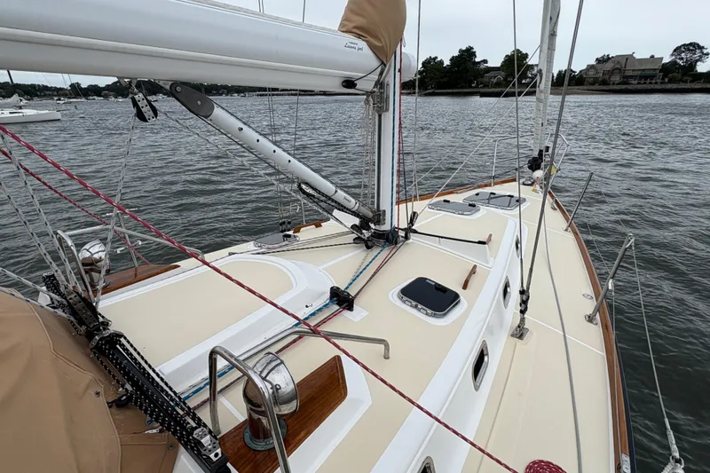 Slide: The Image of 2007 Tartan 3700 CCR sailboat deck with rigging, on calm waters near shoreline. - 6
