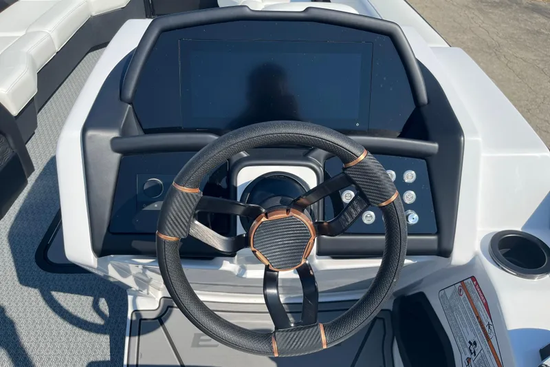 Slide: The Image of Steering wheel and dashboard of 2026 Evotti 725CS boat, featuring modern controls. - 16