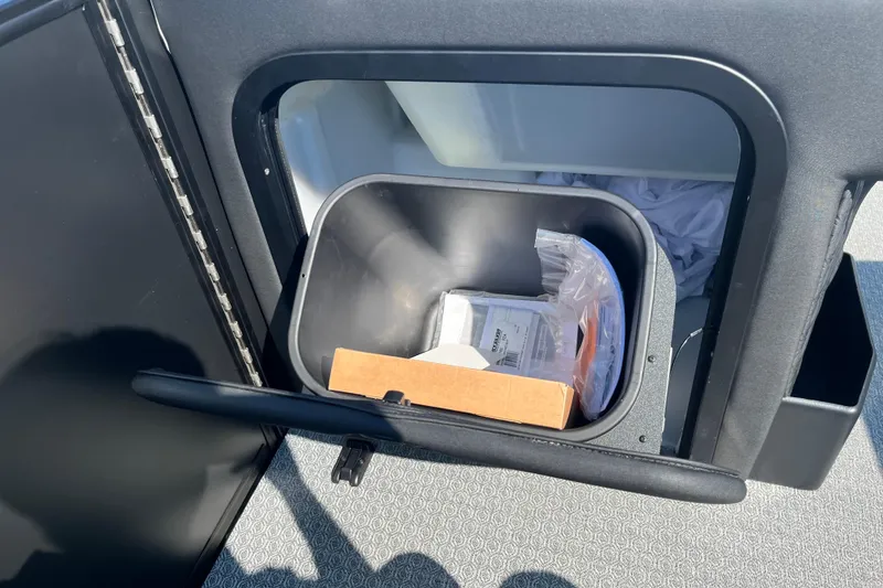 Slide: The Image of Interior storage compartment of 2026 Evotti 725CS with trash bin and items. - 28