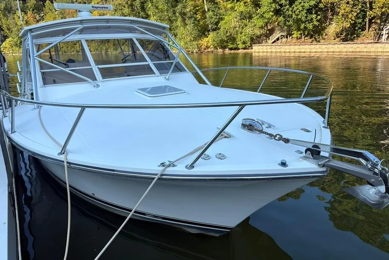 Slide: The Image of 2006 Carolina Classic 32 boat docked on calm water, surrounded by lush greenery. - 1