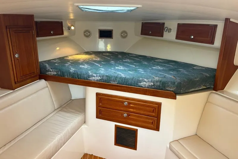 Slide: The Image of Interior cabin of a 2006 Carolina Classic 32 boat with bed and wooden cabinets. - 10