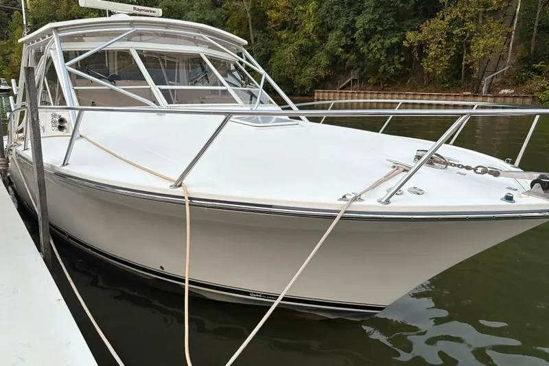 Slide: The Image of 2006 Carolina Classic 32 boat docked on calm water, surrounded by lush greenery. - 12