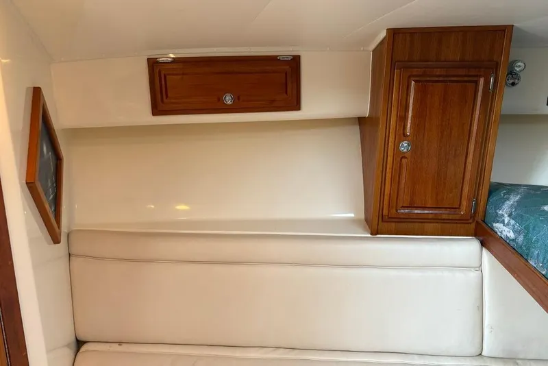 Slide: The Image of 2006 Carolina Classic 32 cabin interior with wooden cabinets and beige seating. - 13