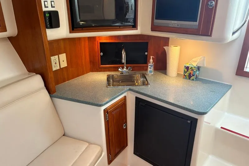Slide: The Image of 2006 Carolina Classic 32 boat interior with kitchenette, sink, and storage cabinets. - 14