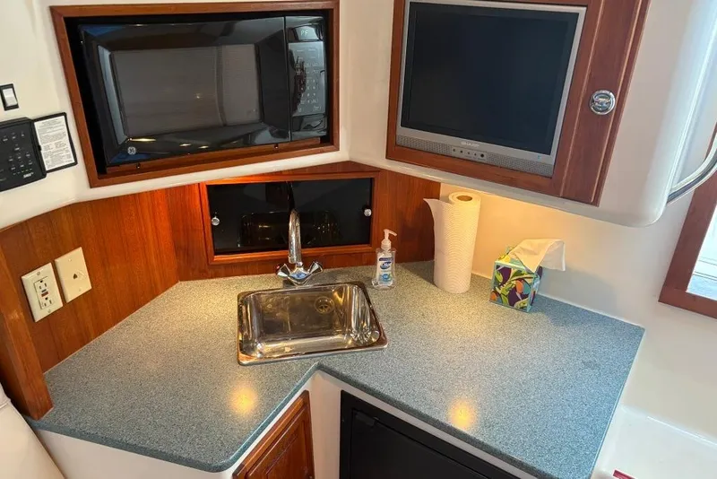 Slide: The Image of 2006 Carolina Classic 32 boat interior with sink, microwave, and countertop essentials. - 17