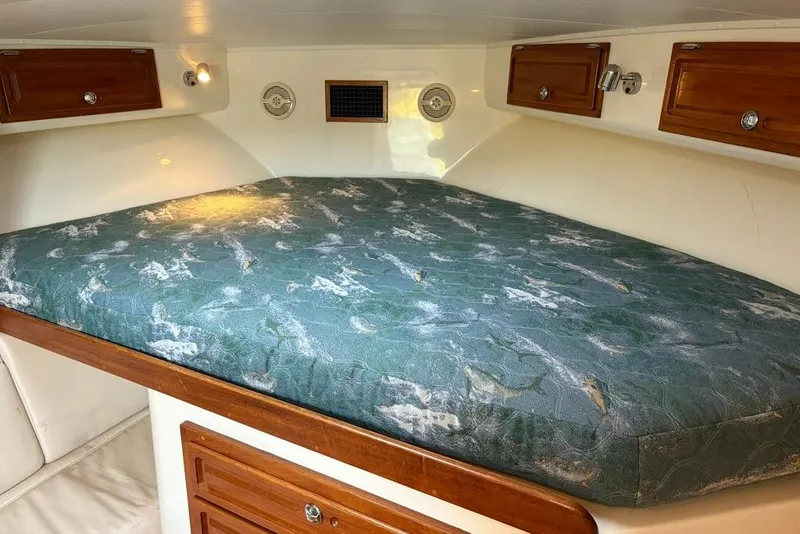 Slide: The Image of 2006 Carolina Classic 32 cabin interior with a patterned mattress and wooden storage cabinets. - 18