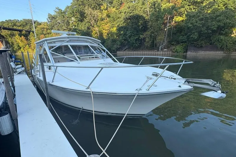 Slide: The Image of 2006 Carolina Classic 32 boat docked on calm water, surrounded by lush greenery. - 20