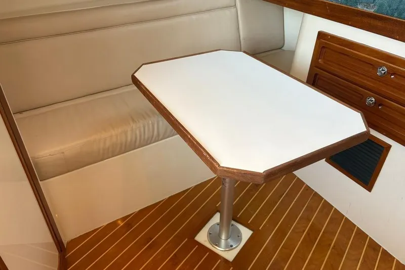 Slide: The Image of Interior of a 2006 Carolina Classic 32 boat with a wooden table and seating. - 23