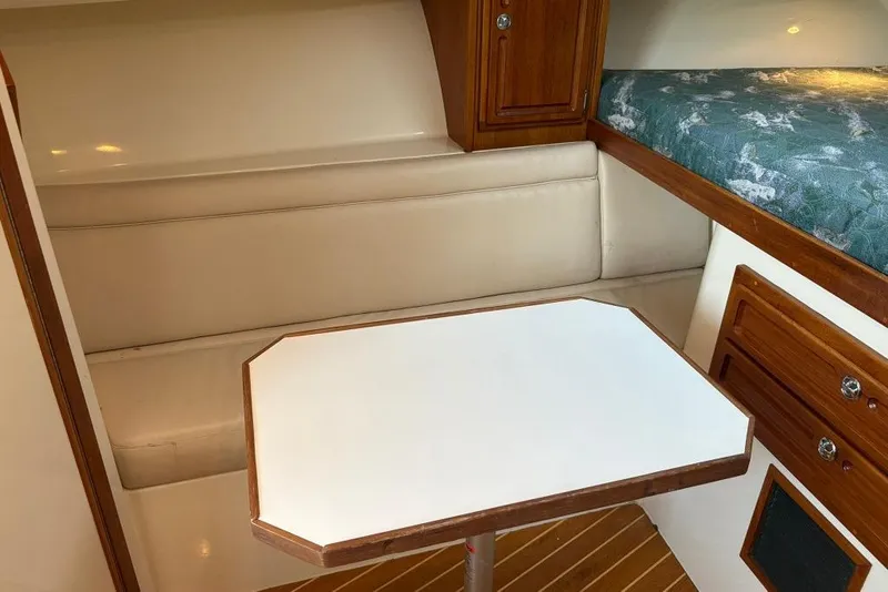 Slide: The Image of 2006 Carolina Classic 32 cabin interior with seating, table, and wooden cabinetry. - 24